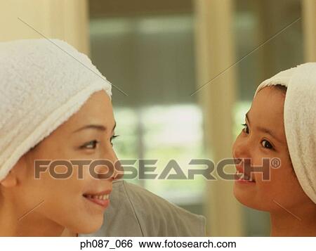 Stock Photograph - Mother and daughter wearing towel wrapped on head . Fotosearch