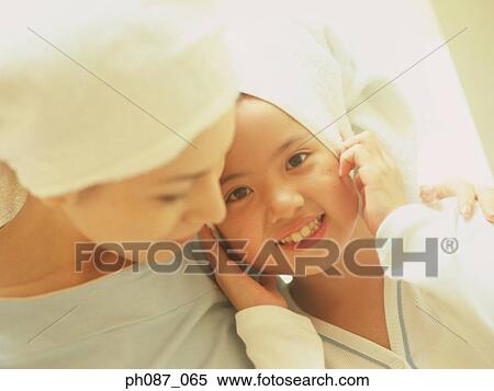 Stock Photography - Mother and daughter wearing towel wrapped on head . Fotosearch