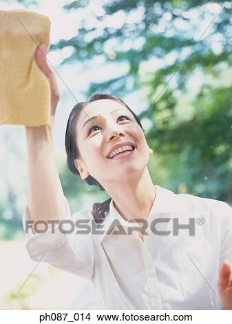 Mother wiping window, close-up View Large Photo Image Picture - Mother wiping window, close-up. Fotosearch