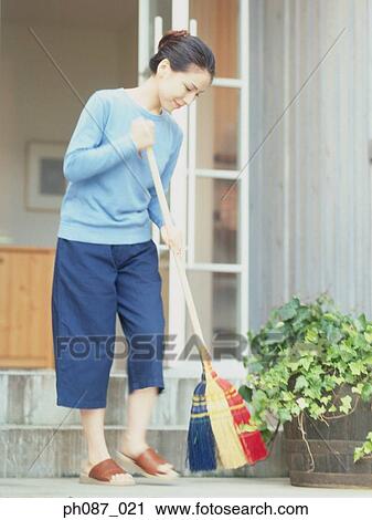 Stock Image - Woman sweeping floor. Fotosearch