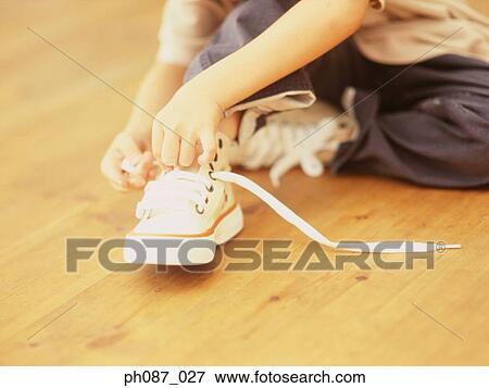 Stock Photo - Young boy tying shoelaces. Fotosearch
