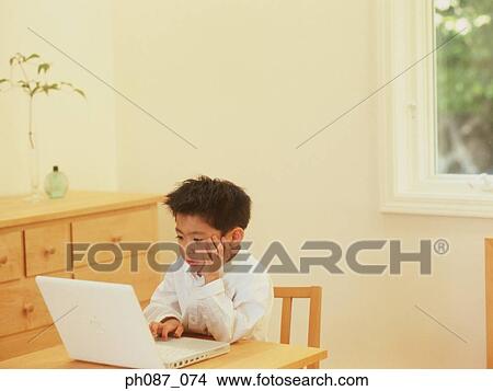 Picture - Young boy using laptop computer . Fotosearch