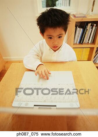 Young boy using laptop computer View Large Photo Image Stock Photography - Young boy using laptop computer . Fotosearch