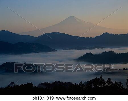 Distant view of Mount Fuji silhouetted against orange sky View Large Photo Image Stock Photo - Distant view of Mount Fuji silhouetted against orange sky . Fotosearch