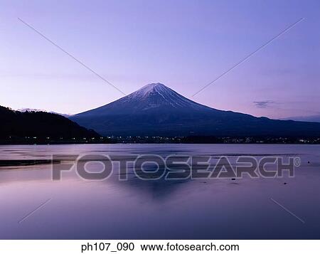 Stock Image - Japan, Mt Fuji, peak in pink winter sunlight, reflected in lake . Fotosearch