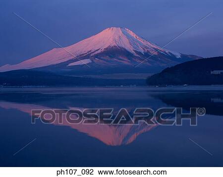 Stock Image - Japan, Mt Fuji, peak in pink winter sunlight, reflected in lake . Fotosearch