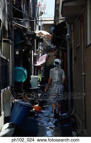 Picture - Japanese woman in back lane, rear view. Fotosearch