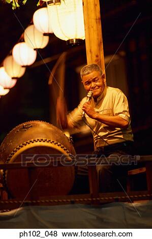 Stock Photo - Portrait of a matured Japanese man holding a microphone. Fotosearch