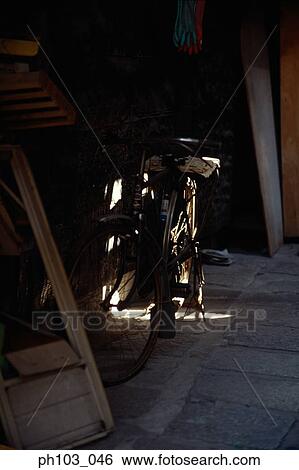 A bicycle parked along a small storage area View Large Photo Image Stock Photograph - A bicycle parked along a small storage area. Fotosearch