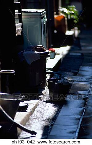 Stock Image - Pots and pails in a small alley. Fotosearch