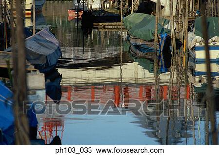 Wooden boats dock at sides of a canal View Large Photo Image Stock Image - Wooden boats dock at sides of a canal. Fotosearch