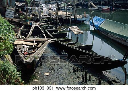 Stock Image - Wretched wooden boats along a canal. Fotosearch