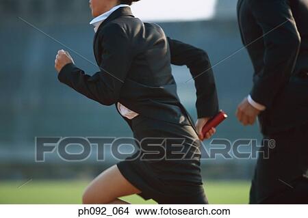 Picture - Businessman passing baton in a relay event . Fotosearch