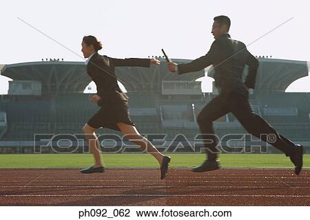 Stock Image - Businessman passing baton in a relay event . Fotosearch