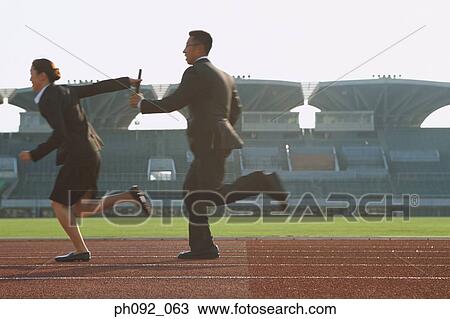 Stock Image - Businessman passing baton in a relay event . Fotosearch