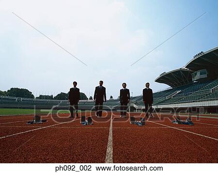 Stock Image - Businessman walking towards starting block . Fotosearch