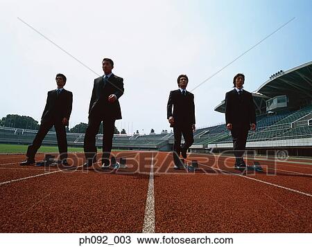Stock Image - Businessman walking towards starting block . Fotosearch