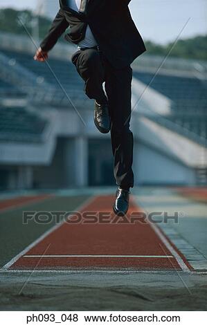Businessman long jumping in mid-air View Large Photo Image Stock Photo - Businessman long jumping in mid-air. Fotosearch