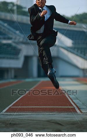 Businessman long jumping in mid-air View Large Photo Image Stock Photograph - Businessman long jumping in mid-air. Fotosearch