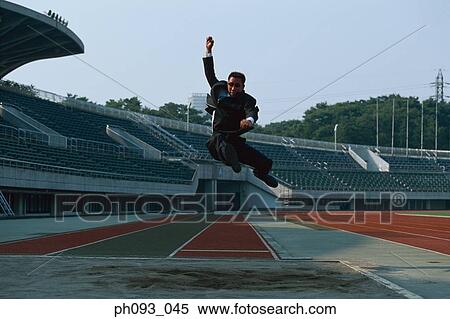 Stock Photography - Businessman long jumping in mid-air. Fotosearch