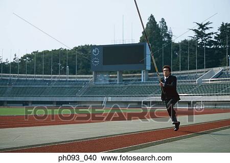 Stock Image - Businessman pole vaulter. Fotosearch