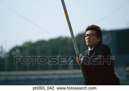 Stock Image - Businessman pole vaulter. Fotosearch