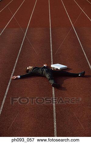 Fallen businessman on running track View Large Photo Image Stock Photo - Fallen businessman on running track. Fotosearch