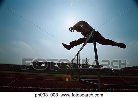 Stock Photo - Silhouette of businessman leaping hurdle. Fotosearch