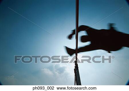 Stock Image - Silhouette of businessman leaping hurdle, low angle view . Fotosearch