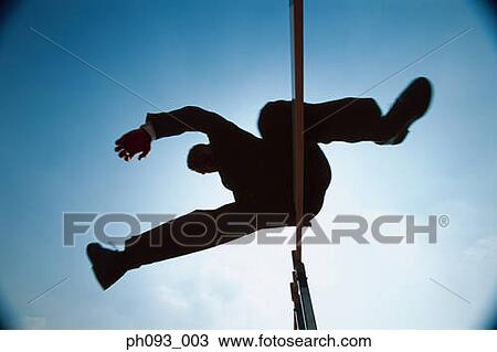 Silhouette of businessman leaping hurdle, low angle view View Large Photo Image Stock Image - Silhouette of businessman leaping hurdle, low angle view . Fotosearch