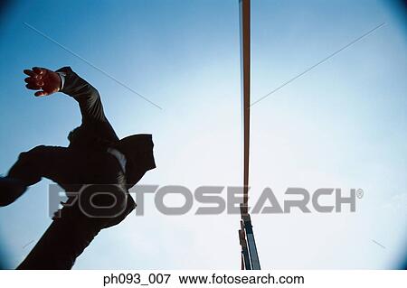 Silhouette of businessman leaping hurdle, low angle view View Large Photo Image Stock Photo - Silhouette of businessman leaping hurdle, low angle view . Fotosearch