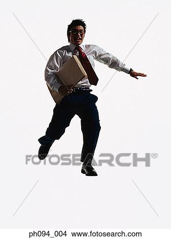 Young businessman leaping in air, holding a envelope View Large Photo Image Picture - Young businessman leaping in air, holding a envelope. Fotosearch