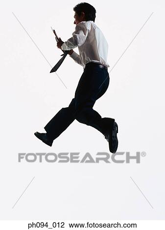 Young businessman leaping in air, holding cell phone in hand View Large Photo Image Stock Image - Young businessman leaping in air, holding cell phone in hand. Fotosearch