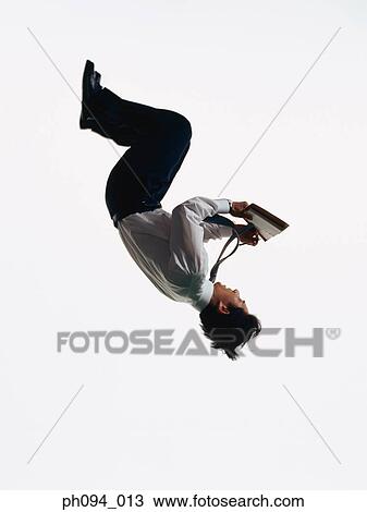 Young businessman leaping in air, holding a notebook in hand View Large Photo Image Stock Image - Young businessman leaping in air, holding a notebook in hand . Fotosearch