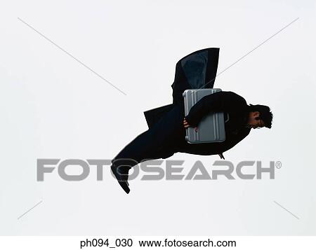 Stock Image - Young businessman leaping in air, holding a briefcase. Fotosearch