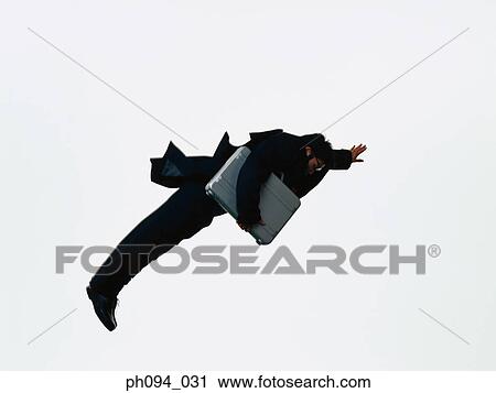Young businessman leaping in air, holding a briefcase View Large Photo Image Stock Image - Young businessman leaping in air, holding a briefcase. Fotosearch