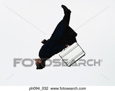 Young businessman leaping in air, holding a briefcase View Large Photo Image Stock Image - Young businessman leaping in air, holding a briefcase. Fotosearch