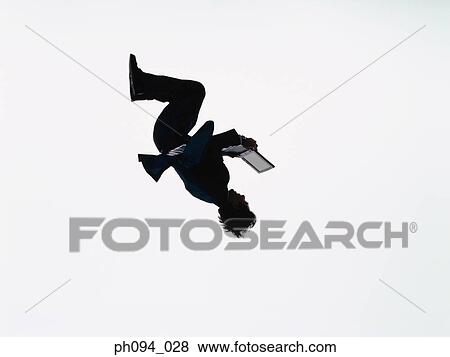 Young businessman leaping in air, holding a computer notebook View Large Photo Image Stock Photo - Young businessman leaping in air, holding a computer notebook. Fotosearch