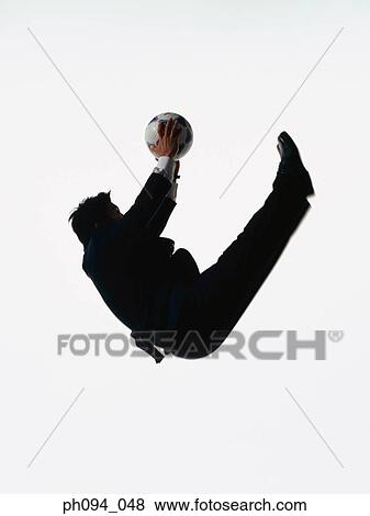 Young businessman leaping in air, holding a soccer ball View Large Photo Image Stock Photo - Young businessman leaping in air, holding a soccer ball. Fotosearch