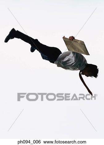 Young businessman leaping in air, holding a envelope View Large Photo Image Stock Photograph - Young businessman leaping in air, holding a envelope. Fotosearch