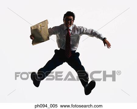Young businessman leaping in air, holding a envelope View Large Photo Image Stock Photography - Young businessman leaping in air, holding a envelope. Fotosearch