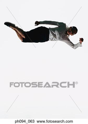 Stock Image - Young businesswoman leaping in air, holding a handbag . Fotosearch