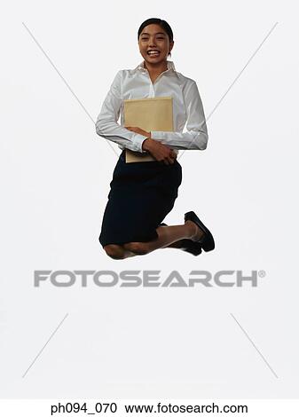 Stock Image - Young businesswoman leaping in air. Fotosearch