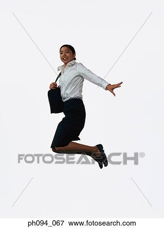 Young businesswoman leaping in air, holding a handbag View Large Photo Image Stock Photo - Young businesswoman leaping in air, holding a handbag . Fotosearch