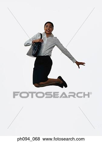 Stock Photo - Young businesswoman leaping in air, holding a handbag . Fotosearch