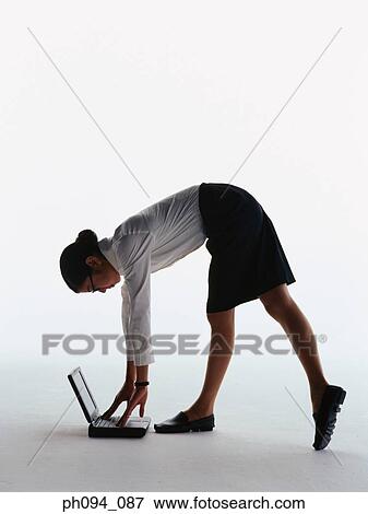 Young businesswoman picking up computer notebook on the floor View Large Photo Image Stock Photo - Young businesswoman picking up computer notebook on the floor. Fotosearch
