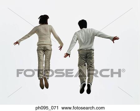Two young Asian man and woman in pants & sweat-shirts, jumping in mid-air View Large Photo Image Stock Image - Two young Asian man and woman in pants & sweat-shirts, jumping in mid-air. Fotosearch