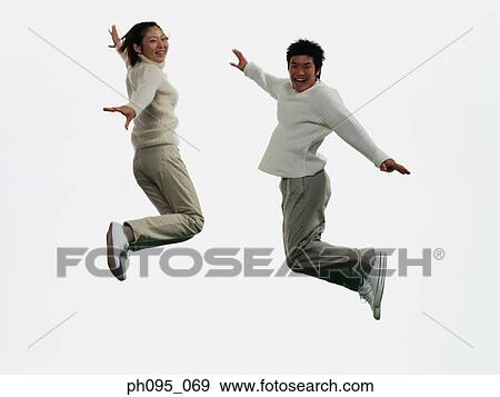 Two young Asian man and woman in pants & sweat-shirts, jumping in mid-air View Large Photo Image Stock Photo - Two young Asian man and woman in pants & sweat-shirts, jumping in mid-air. Fotosearch