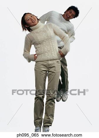 Two young Asian man and woman in pants & sweat-shirts, jumping in mid-air View Large Photo Image Stock Photography - Two young Asian man and woman in pants & sweat-shirts, jumping in mid-air. Fotosearch
