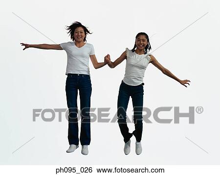 Two young Asian women in jeans & t-shirt, jumping in mid-air View Large Photo Image Stock Photograph - Two young Asian women in jeans & t-shirt, jumping in mid-air. Fotosearch